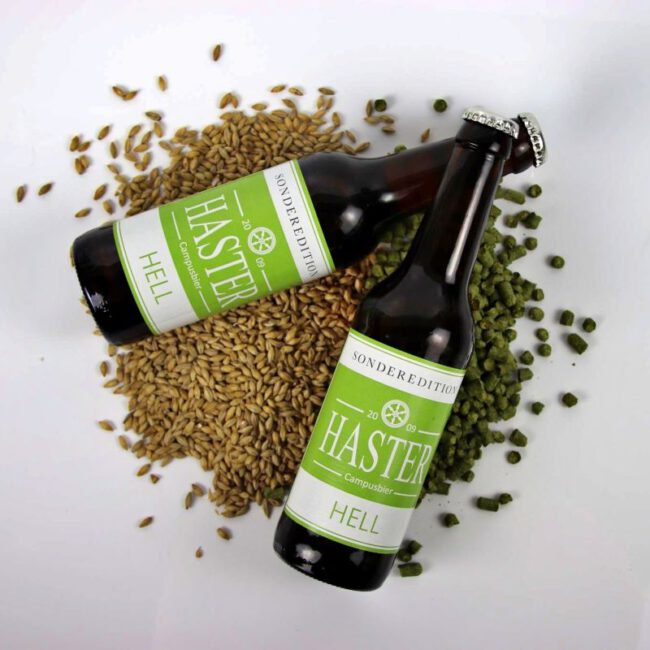 Haster2_web zwei Flaschen Haster hell auf einem kleinen Haufen Gerstenkörner