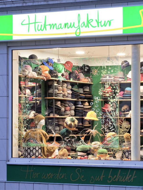 Beleuchtetes Ladengeschäft der Hutmanufaktur von außen